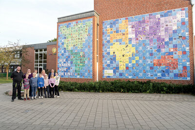 Präsentierten die erneuerte Weltkarte an der St.-Georg-Grundschule als Station des Energie-Erlebnis-Pfad mit klarer Botschaft: Rüdiger Heitmann und Silvana Austermann (Elternvertreter), Maren Eggerichs und Sarah Ortmeier (Schulleitung), Bürgermeister Dr. Tobias Lehberg und die Klassensprecher des vierten Jahrgangs.