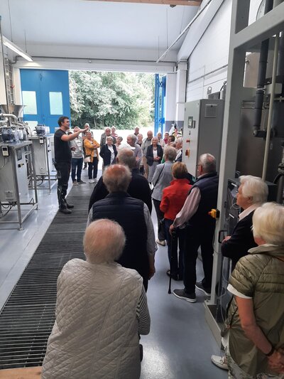 Niklas Olbertz erklärt den Teilnehmerinnen und Teilnehmern der Seniorenrundfahrt den Forschungsstandort der Fachhochschule im Bioenergiepark, dessen Türen normalerweise geschlossen bleiben.