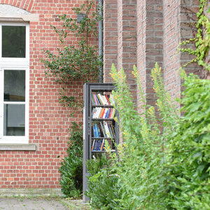 Der offene Bücherschrank für alle steht auf dem Dorfplatz im Eck von köb Bücherei und Pfarrheim St. Georg.